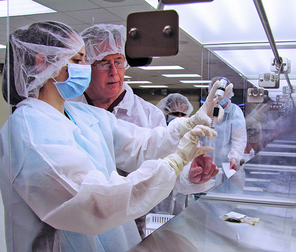 instructor and student measuring a sample in a classroom lab