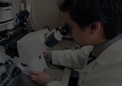 Pharmacy student working with large microscope