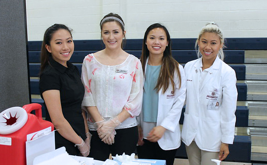 four students working at a community health fair